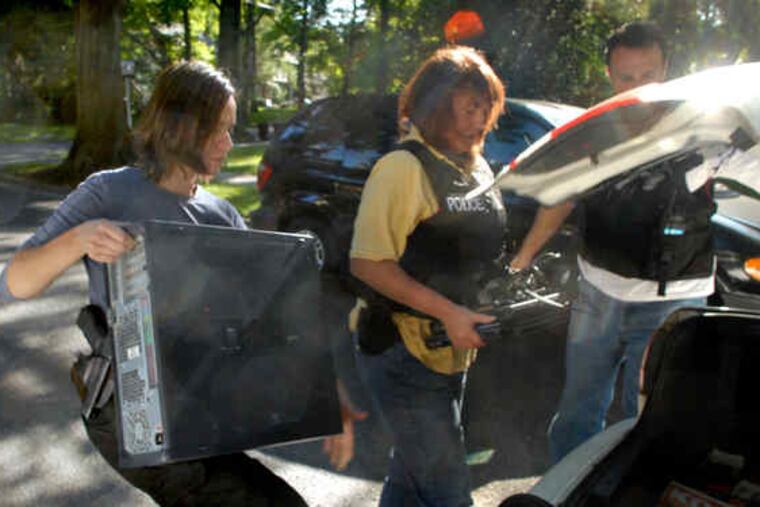 Investigators Lina Ramirez (left) of the FBI and Valerie Hecker of the county prosecutor's office put seized computers into the trunk of Kevin Kellejan's car.