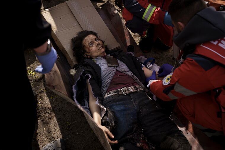 A woman injured in a Russian attack is treated by emergency workers in Kharkiv, Ukraine, Saturday, April 16, 2022. (AP Photo/Felipe Dana)