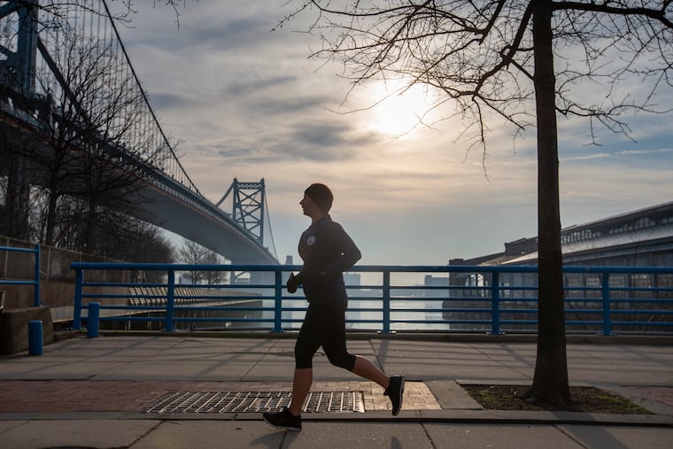 A jogger runs north on Delaware Ave near Race Street Pier in Philadelphia on Thursday morning. The dry weather has been great for runners, but might pose a fire danger.