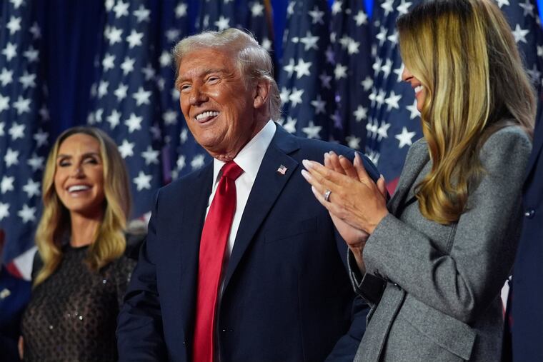 Donald Trump stands on stage with former first lady Melania Trump, as Lara Trump watches, at an election night watch party at the Palm Beach Convention Center on Wednesday in West Palm Beach, Fla.