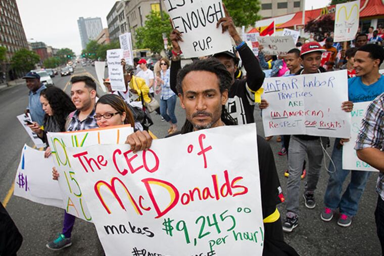 Glenn Davisa marches with other protesters and fast food workers down North Broad St. towards Arch Street on Thursday, May 15, 2014. This group is demanding a wage increase for fast food workers. ( ALEJANDRO A. ALVAREZ / STAFF PHOTOGRAPHER )
