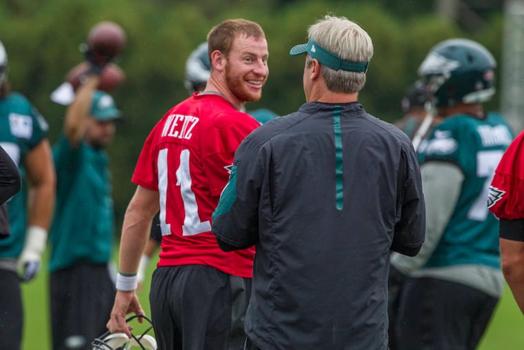 Eagles coach Doug Pederson re-emphasized that Carson Wentz will still be the team's starting quarterback when he is healthy again. "He's our guy," Pederson said.
Eagle quarterback Carson Wentz, #11, turns to smile back at head coach Doug Pederson during Tuesday’s practice. 08/15/2017 MICHAEL BRYANT / Staff Photographer