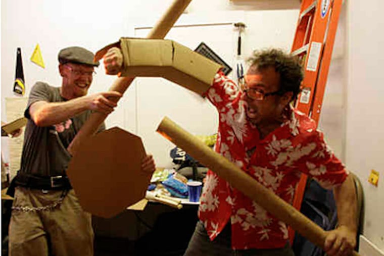 Far McKon (left) and Johnny Goldstein joust with cardboard swords in preparation for tomorrow's Cardboard Tube Fighting League Tournament. (Yong Kim / Staff Photographer)