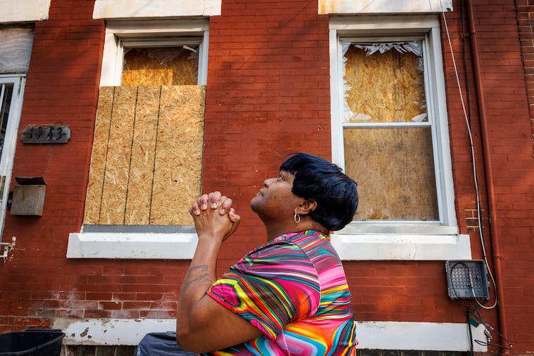 Tawanda Davis, a resident of 1900 block of West Bristol Street, has been living with boarded-up windows after an explosion across the street from her rented rowhouse. She took a moment to pray before returning to the home: “God bless us with new windows or a new home.” According to Davis, the landlord is aware of the situation.