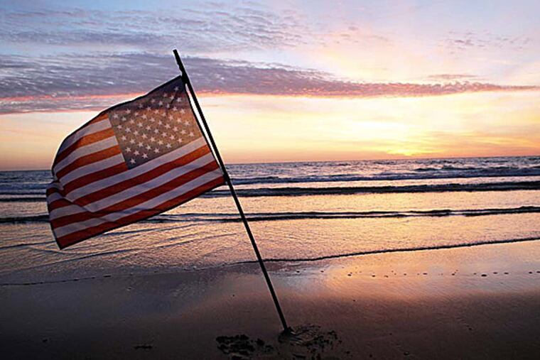 An American flag is placed in the sand of Omaha Beach in Normandy to honor the troops who participated in the invasion. (Thibault Camus/AP)