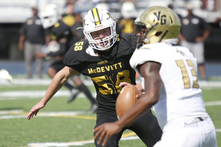 Bishop McDevitt lineman Sean Stanton (58) pursues Neumann-Goretti quarterback Rausheen Lively (13) in the third quarter of Saturday's Catholic League Blue Division game.