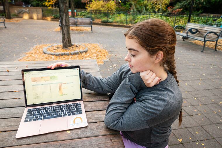 Abby Bailey, an occupational therapist, looks at her budget in Kahn Park in Philadelphia, Wednesday, Nov. 8, 2023. Budgeting is one of the finance-related resolutions some may be making for 2024.