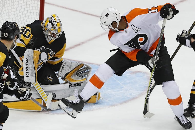 Penguins goaltender Matt Murray stops a shot with Flyers winger Wayne Simmonds (right) looking for a rebound during a March 25 game, won in overtime by Pittsburgh, 5-4.