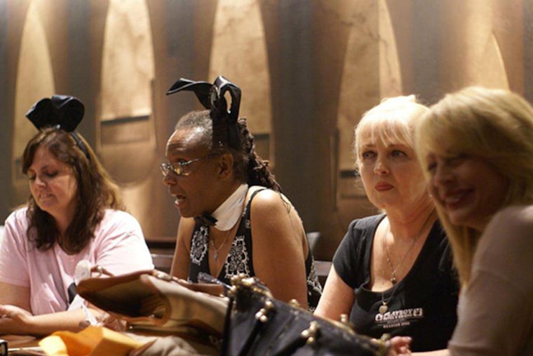 Left to right, Diana Brooks, Sheree Harden, and Sandy Collison look over memorabilia during a Baltimore reunion of former Playboy bunnies. All three worked at the Playboy Casino in Atlantic City in the early 1980s. (Jeff Stroud photo)