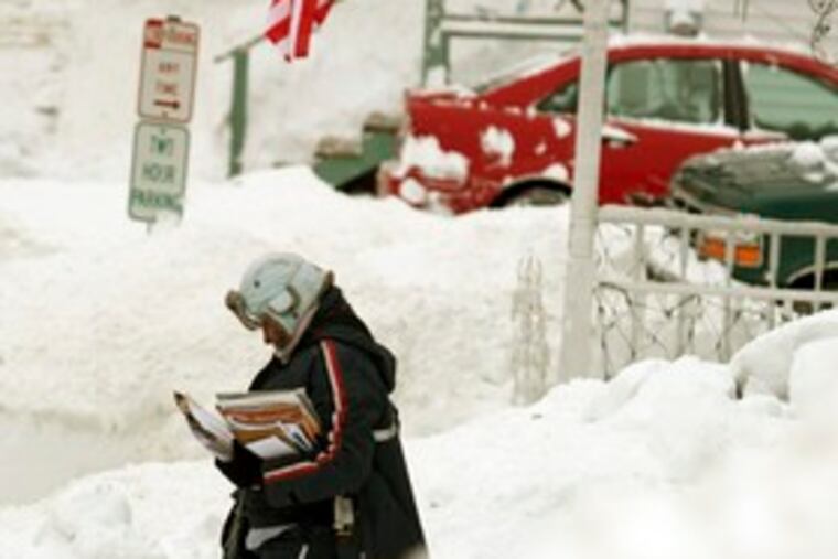Letter carrier Adriana Hansen trudges along a street in Bath, Maine. Snow blanketed most of the state Sunday, with some regions receiving more than three feet. Story, A15.