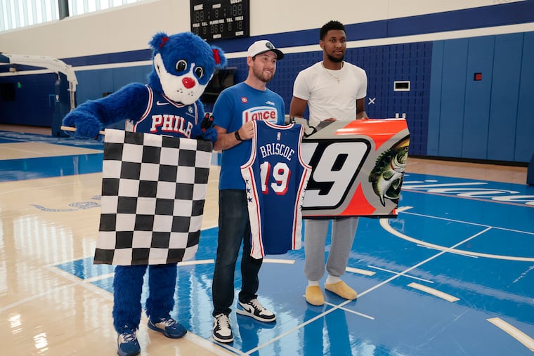 NASCAR driver Chase Briscoe (center), and Sixers forward Justin Edwards exchanged No. 19 memorabilia on Tuesday. With them is the Sixers' mascot, Franklin.