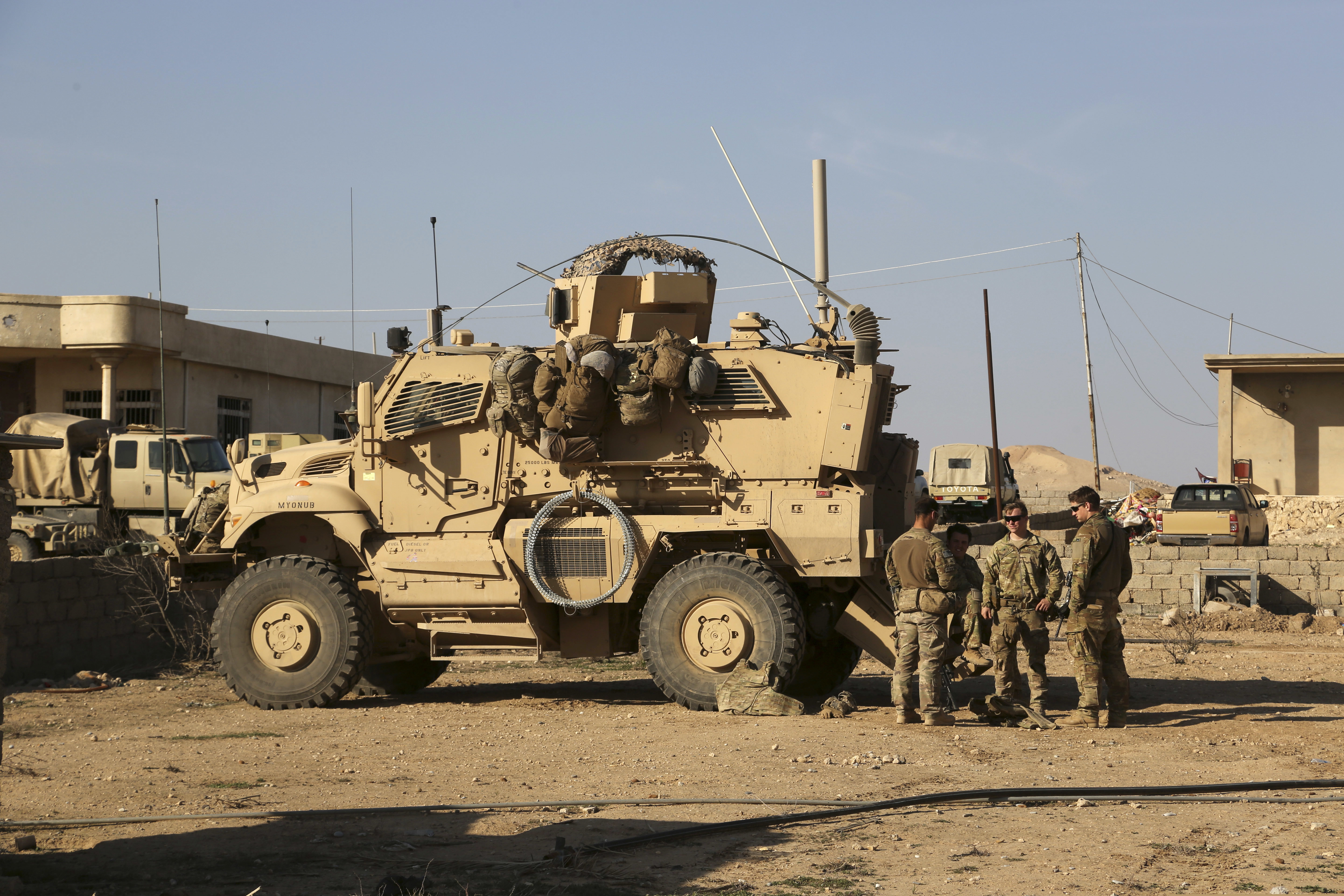 In this February 2017 photo, U.S. Army soldiers stand outside their armored vehicle on a joint base with the Iraqi army south of Mosul, Iraq. Iraqi security officials say 17 Katyusha rockets have hit an Iraqi air base south of the city of Mosul that houses American troops.