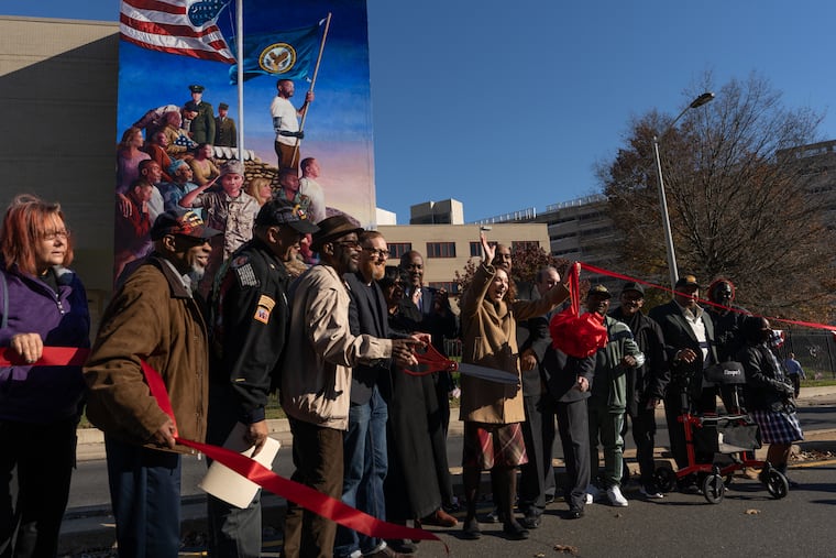 The ribbon is cut during a dedication ceremony for a new mural by James Burns at Philadelphia's Veterans Affairs Medical Center Nov. 8. Less than one in four veterans nationwide receive adequate mental health care.