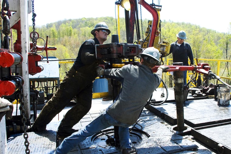 Workers move a section of well casing into place at a Chesapeake Energy natural gas well site in Bradford County in 2010.