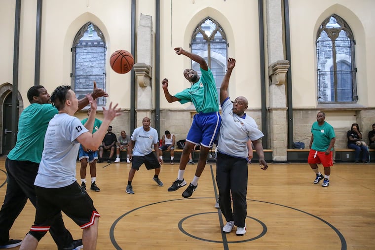 Players from the Outley House go up against Our Brothers' Place during a game at the Church of the Advocate in North Philly on Wednesday. Men from both shelters participate in a basketball league run by Hoops for Hope.