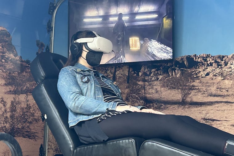 Erin Bailey takes part in a virtual alien abduction at 36th and Walnut Streets on Friday. The experience is designed to parallel the sci-fi scenario with medical research on animals.
