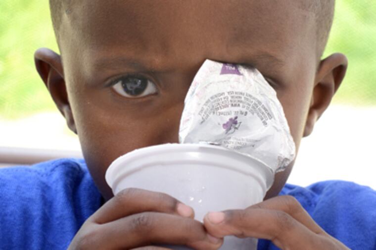 Khaseem Vincent, 3, drinks juice given to him by Angela Prattis (not pictured), as part of her initiative. (Tom Gralish / Staff Photographer)
