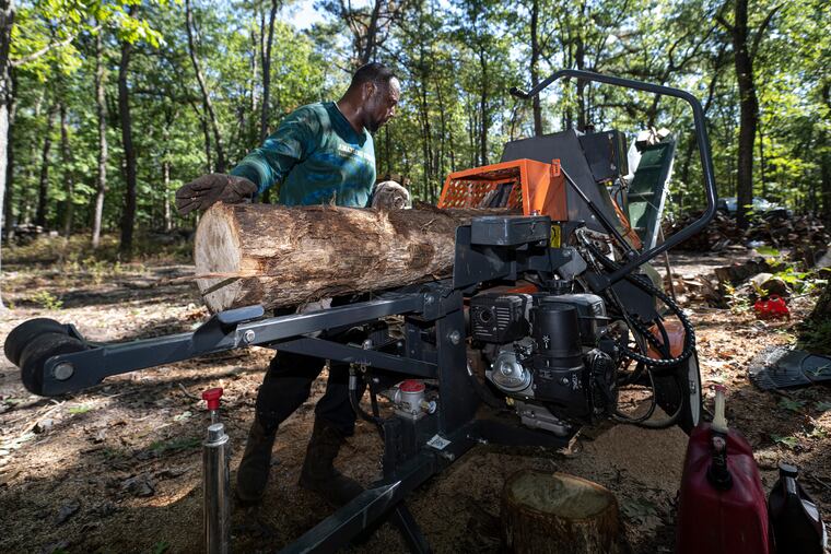 Andrew Mays loads an oak log onto a firewood processor in the yard at his parents' house in Hammonton, N.J. Amaysing Wood is a small Black-owned, veteran-owned business established in 2020 in Delaware. They sell wood for heating one's home, smoking meats, or for bonfires.