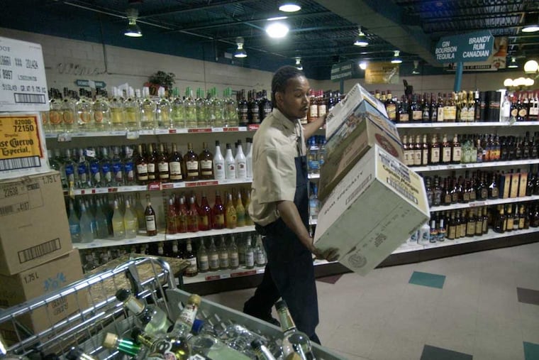 LCB employee Larry Smith stocking shelves in 2005 at the State Store in Franklin Mills,. (Jonathon Wilson/ File Photograph)