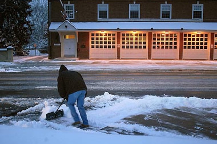 Joe Armstrong shovels the sidewalk at Kings Highway and Haddon Avenue in Haddonfield early yesterday. (Tom Gralish/Staff Photographer)