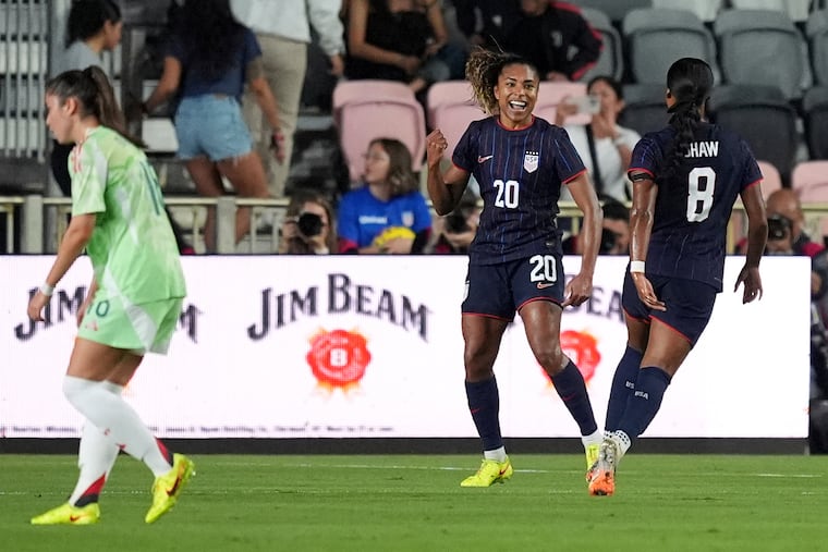 Catarina Macario (center) celebrates with Jaedyn Shaw (left) after scoring the game's opening goal.