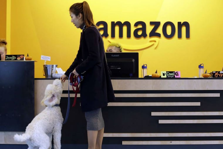 FILE - In this Wednesday, Oct. 11, 2017, file photo, an Amazon employee gives her dog a biscuit as the pair head into a company building, where dogs are welcome, in Seattle. Amazon announced Thursday, Jan. 18, 2018, that it has narrowed its hunt for a second headquarters to 20 locations, concentrated among cities in the U.S. East and Midwest. Toronto made the list as well, keeping the company's international options open.