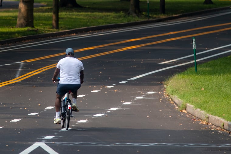 A cyclist on a bike-share bicycle merges onto Martin Luther King Drive from Strawberry Mansion Bridge access on Wednesday, July 21, 2021.