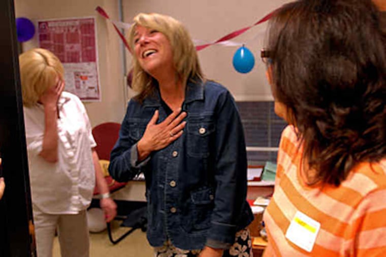 Guidance counselor Kathy Teague is surprised by her office makeover, courtesy of Cathie (left) and Brianna O'Donnell, the mother and sister of Shane O'Donnell. (Tom Gralish / Staff)