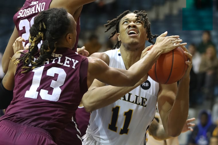 Ed Croswell, right, of La Salle goes up for a shot in front of Joel Soriano, left, and Antwon Portley of Fordham during the 2nd half on Feb. 19, 2020.