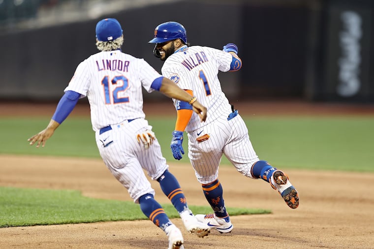 Jonathan Villar (1) of the New York Mets celebrates his hit, which drove in the game-winning run, as he is chased by teammate Francisco Lindor (12) in the eighth inning against the Phillies.