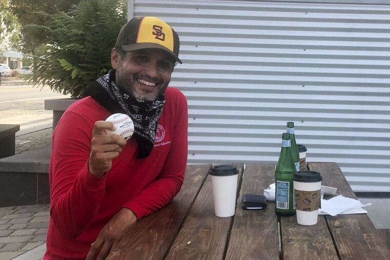 San Diego Padres fan Vinicio Lopez holds up a gifted foul ball in Alameda, Calif.