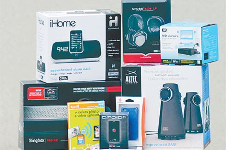 The gadgets (clockwise from bottom left): Slingbox, iHome alarm clock, Crossface v-moda headphones, WD Livewire, Altec speakers, Griffin phone case, and Eye-fi photo card. (Sarah J. Glover / Staff Photographer)