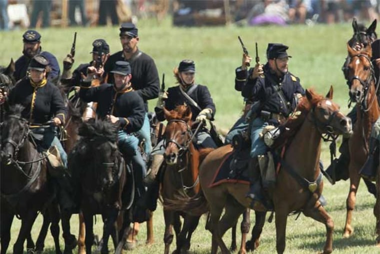 Union cavalry reenactors wheel their horses to the left to cut off the retreat of the Confederate Cavalry during a reenactment of the cavalry battle known as the "Ambush at Hunterstown" during the second day of 150th Gettysburg anniversary reenactment. (Michael Bryant / Staff Photographer)