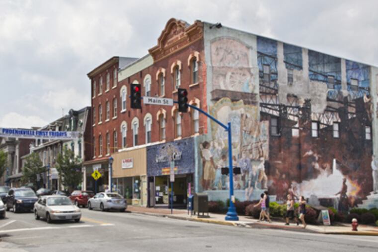 The Phoenixville Mural, located at the corner of Bridge and Main Streets, reflects Phoenixville's iron and steel history and its location on the Schuylkill River, pictured here July 16 2012. It gives residents a view into the Old Steel Mill's past as its creators took stories from those who knew about its origins. (ELISE WRABETZ / Staff Photographer)