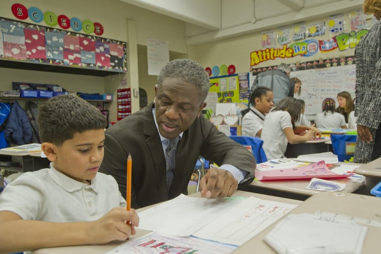 Assistant Superintendent for the School District of Philadelphia Dr. Eric Becoats talks to third grader Anthony Rodriguez, 8, during a tour of some of the classes before the School Progress Report awards ceremony at the Potter-Thomas Elementary School on January 29, 2018.