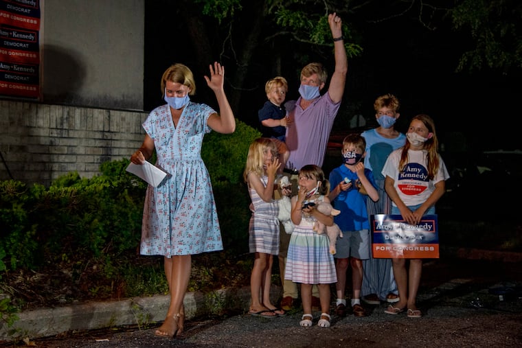 Amy Kennedy steps forward as she declares victory in New Jersey’s 2nd Congressional District Democratic primary in Northfield on Tuesday. At right, her husband, former U.S. Rep. Patrick Kennedy, with their children.