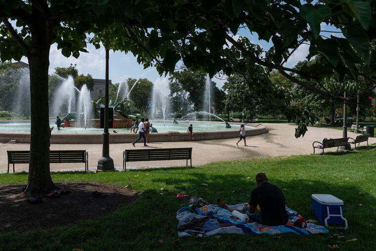 People spend time at Swann Memorial Fountain in Logan Circle during a heat wave in July.
