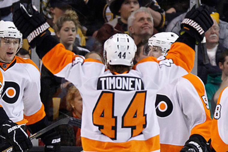 Kimmo Timonen celebrates James van Riemsdyk's goal in the second period. (AP Photo/Michael Dwyer)