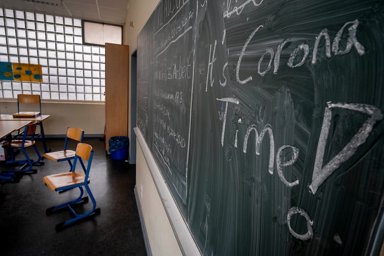 FILE -- In this Friday, March 13, 2020 photo a slogan on a chalkboard reads 'It's Corona Time' in an empty class room of a high school in Frankfurt, Germany, March 13, 2020. Germany plans to let smaller shops reopen next week after a weeks-long coronavirus shutdown and to start reopening schools in early May, but Europe’s biggest economy is keeping strict social distancing rules in place for now. (AP Photo/Michael Probst, file)
