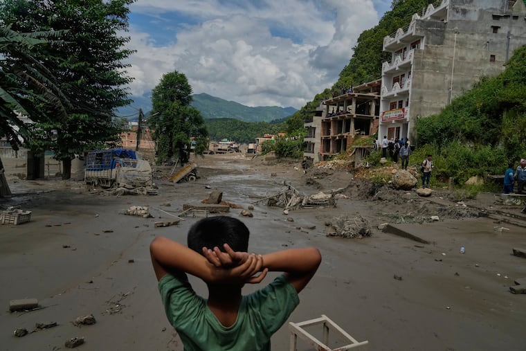 A boy looks at the devastation caused by flash flooding along the Trishuli River in Nepal's Nuwakot district, Wednesday, Aug. 26, 2026. (AP Photo/Niranjan Shrestha)