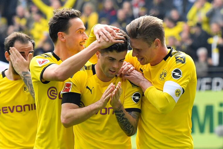 Dortmund's Christian Pulisic, center, celebrates after scoring the opening goal during the German Bundesliga soccer match between Borussia Dortmund and Fortuna Duesseldorf in Dortmund, Germany, Saturday, May 11, 2019. (AP Photo/Martin Meissner)