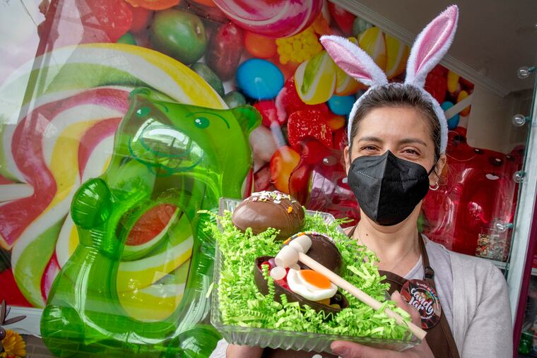 Paula Alban, owner of The Candy Jar by 1892 in downtown Collingswood, poses with her "Smash Egg" on Sunday. The Easter special comes in a white, dark or milk chocolate egg shell you crack open to reveal jelly beans, a gummy egg, and edible grass inside. They came up with this idea because COVID-19 forced them to get "creative."