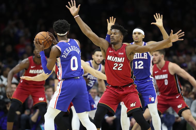 Jimmy Butler, center, and the Heat apply a zone defense against the Sixers during the second half.