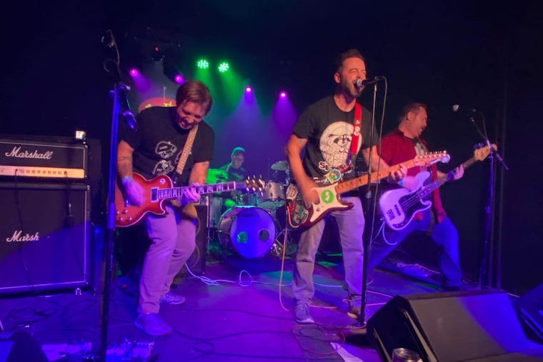 Philly firefighter Randy Ballinger, far right, shreds on the bass during a performance with his band, Jersey Calling.