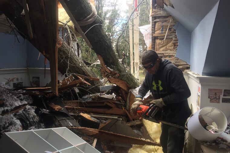 A worker cuts up the oak tree that bisected Courtenay Harris Bond's house in Bala Cynwyd on March 2, 2018. The second and third floors were destroyed.