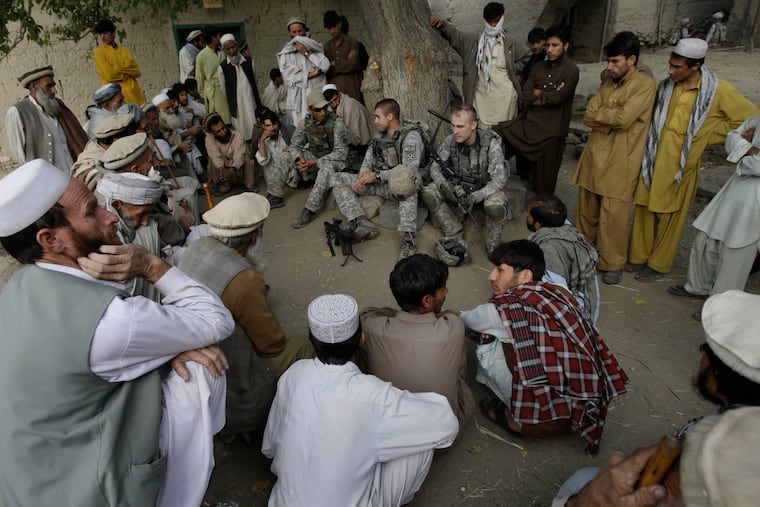 Lt. Thomas Goodman (center), of the 2nd Battalion, 12th Infantry Regiment, 4th Brigade Combat Team, 4th Infantry Division, meets with villagers in Qatar Kala in the Pech Valley of Afghanistan's Kunar province with his interpreter, Ayazudin Hilal (center left with hat), in 2009. If State Department officials get their way, some Afghans who worked alongside U.S. service members may be sent to Congo, writes Trudy Rubin.