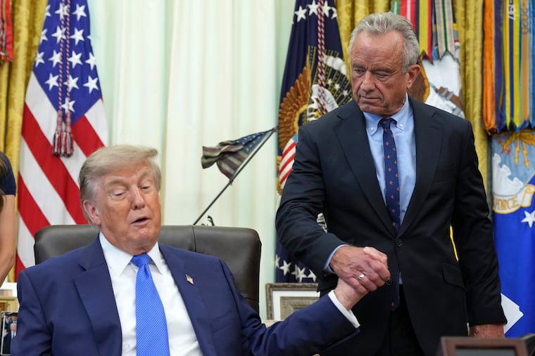 President Donald Trump shakes the hand of Health and Human Services Secretary Robert F. Kennedy Jr. during a meeting to sign an executive order about vaccines Monday at the White House.