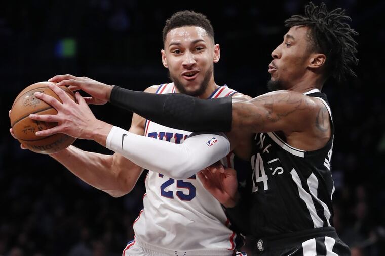 Brooklyn Nets forward Rondae Hollis-Jefferson, right, gets this hand on the ball as Philadelphia 76ers guard Ben Simmons, left, looks to pass during the first half of an NBA basketball game, Sunday, March 11, 2018, in New York.