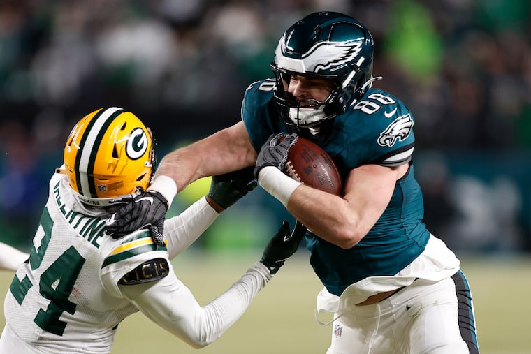 Eagles tight end Dallas Goedert stiff-arms Green Bay Packers cornerback Carrington Valentine in an NFC wild-card game on Jan. 12.