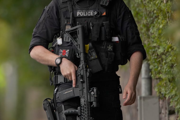 An armed police officer patrols near the scene of a car and knife attack at Heaton Park Hebrew Congregation synagogue in Manchester, England, on Thursday, Oct. 2.